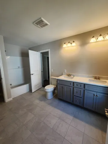 a spacious bathroom with a granite countertop sink and mirror