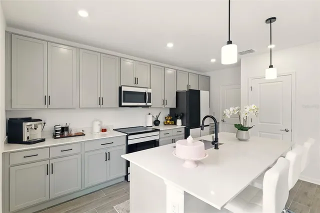 a kitchen with appliances a sink and cabinets