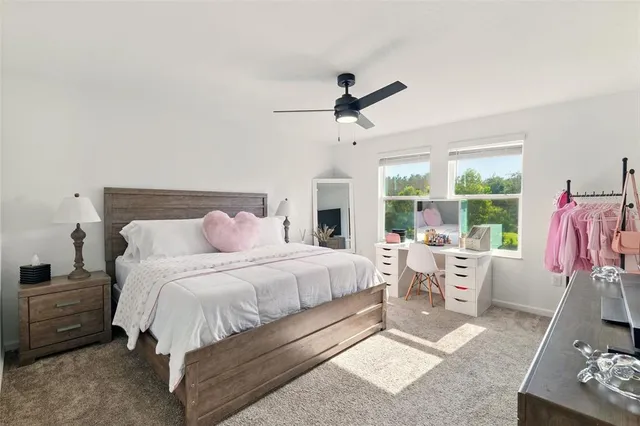 a spacious bedroom with a bed a couch and large window