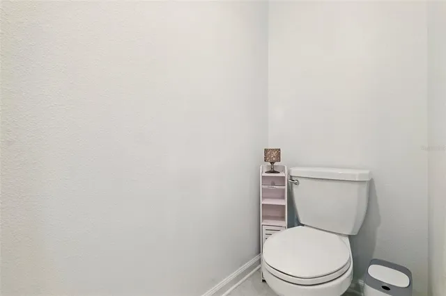 a white toilet sitting next to a white wall