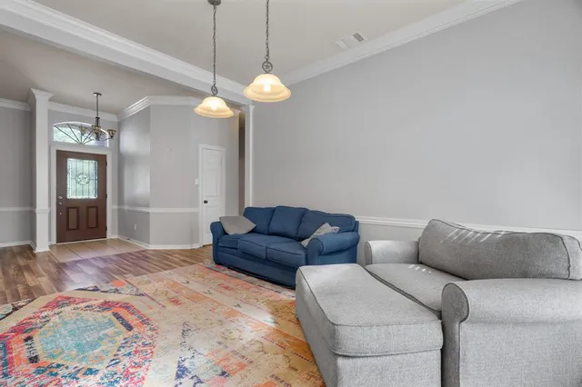 a living room with furniture a chandelier and a rug
