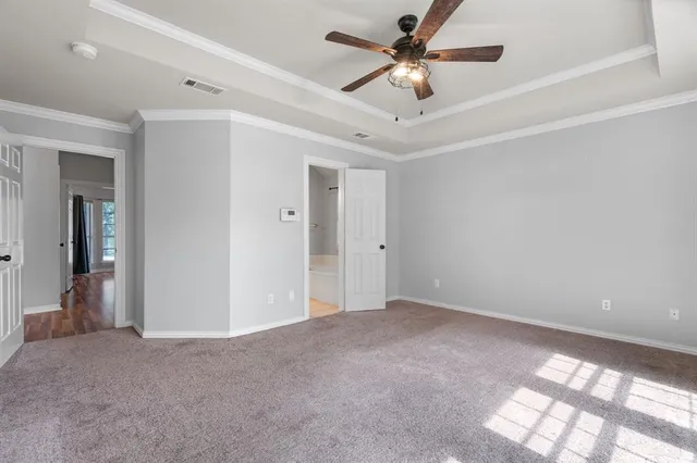 an empty room with closet and a ceiling fan