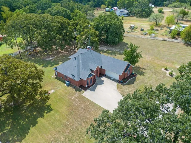 an aerial view of a house with a yard and lake view