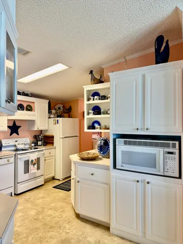a kitchen with white cabinets and appliances