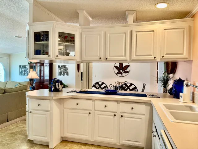 a kitchen with white cabinets and sink
