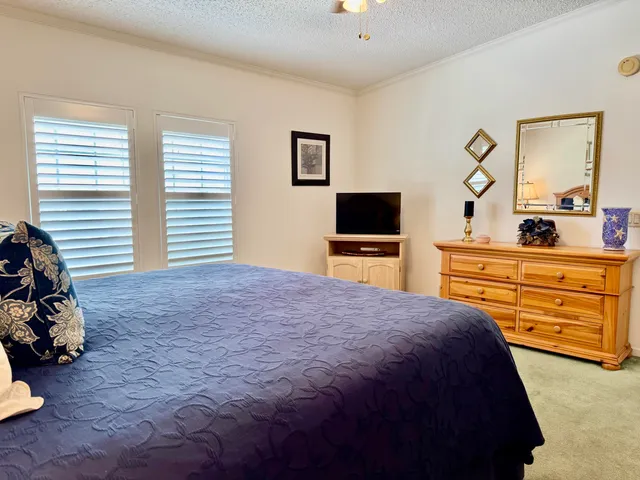a bedroom with a bed and a tv on dresser