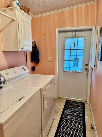 a room with a washing machine and cabinets