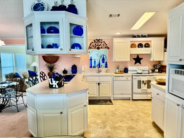 a kitchen with white cabinets and appliances