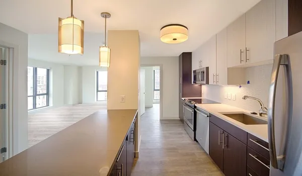 a large kitchen with stainless steel appliances granite countertop a lot of counter space and wooden floors