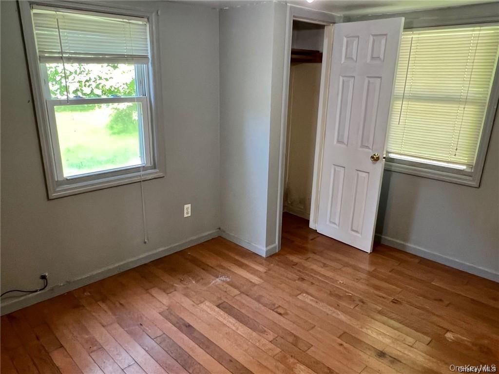 22 Kelly Hill Road, Unit 3 Otisville, NY 10963 - Photo 12 of 16 an empty room with wooden floor and windows
