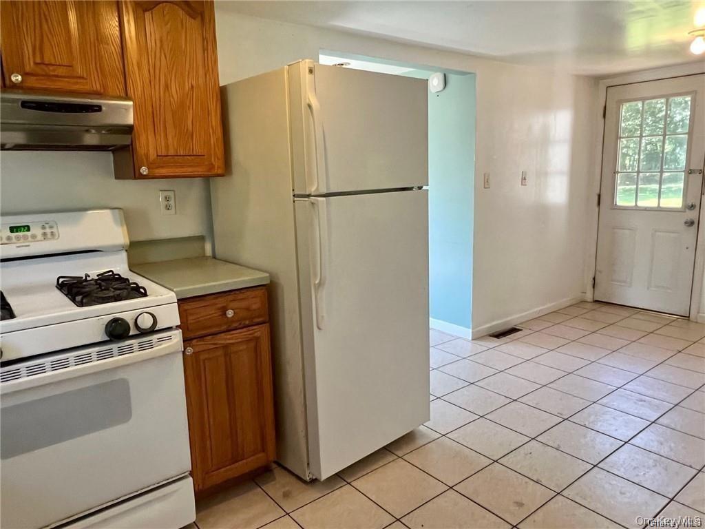 22 Kelly Hill Road, Unit 3 Otisville, NY 10963 - Photo 5 of 16 a kitchen with a refrigerator and a stove top oven