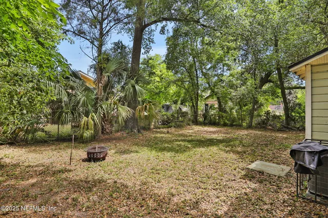 a view of a house with a yard and large tree