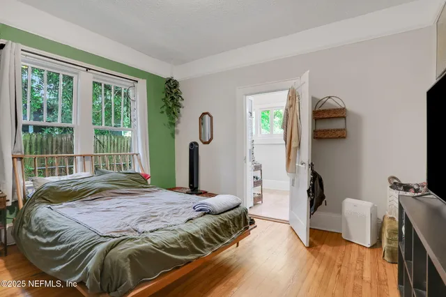 a bedroom with a bed and wooden floor