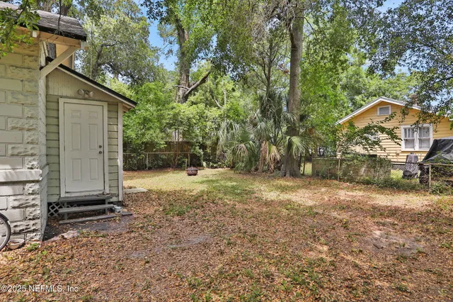 a view of a house with backyard and trees