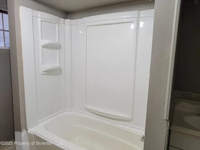 an empty room with wooden floor and entrance