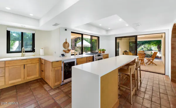 a view of living room kitchen with furniture and large windows