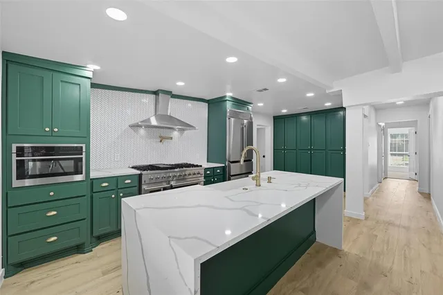 a large kitchen with kitchen island a sink stainless steel appliances and cabinets