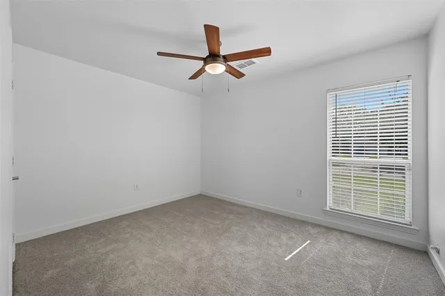 a view of a livingroom with a ceiling fan and window