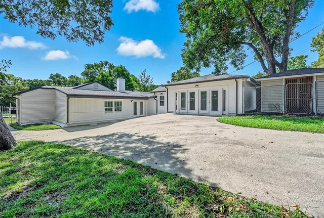 a view of a house with a yard and large tree