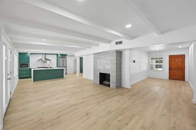 a view of an empty room with a fireplace and a window