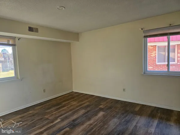 a view of a room that has wooden floor and cabinets