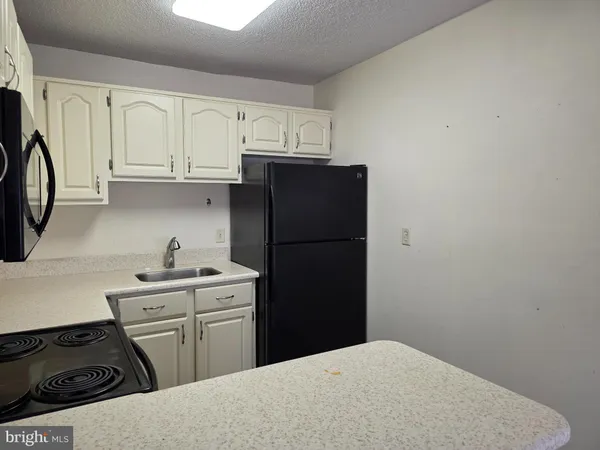 a kitchen with a refrigerator and a stove top oven