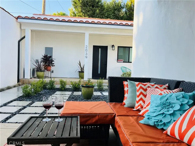a backyard of a house with fire pit table and chairs