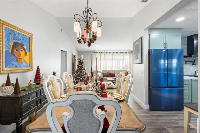 a view of a dining room with furniture a chandelier and wooden floor