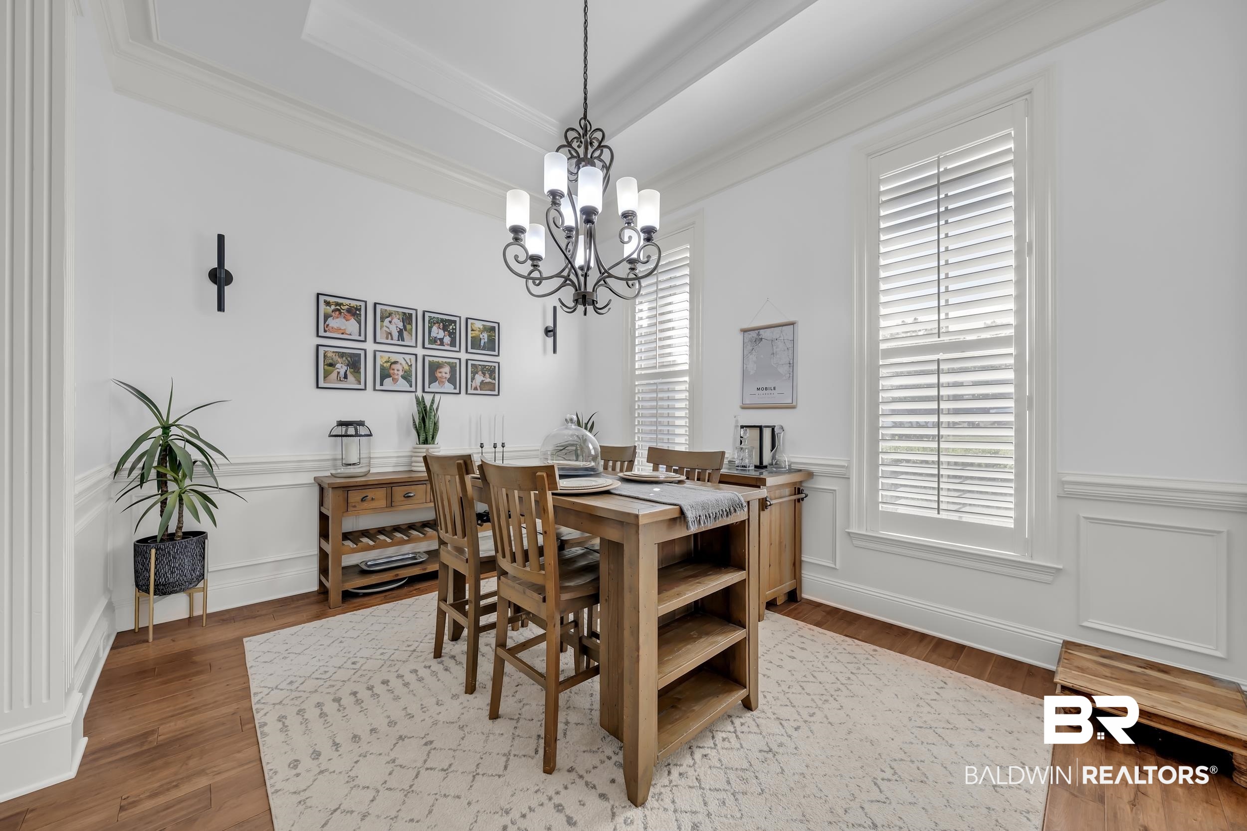 8137 Pine Run Daphne, AL 36527 - Photo 10 of 67 Dining area featuring wood-finish flooring, white paneled walls, and a recessed ceiling with crown molding
