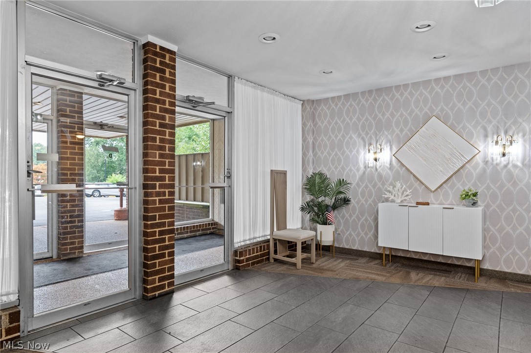 3070 Kent Road, Unit 312D Stow, OH 44224 - Photo 3 of 49 Entryway featuring brick columns, full-light entry doors, tile flooring, textured wallpaper, and recessed lighting