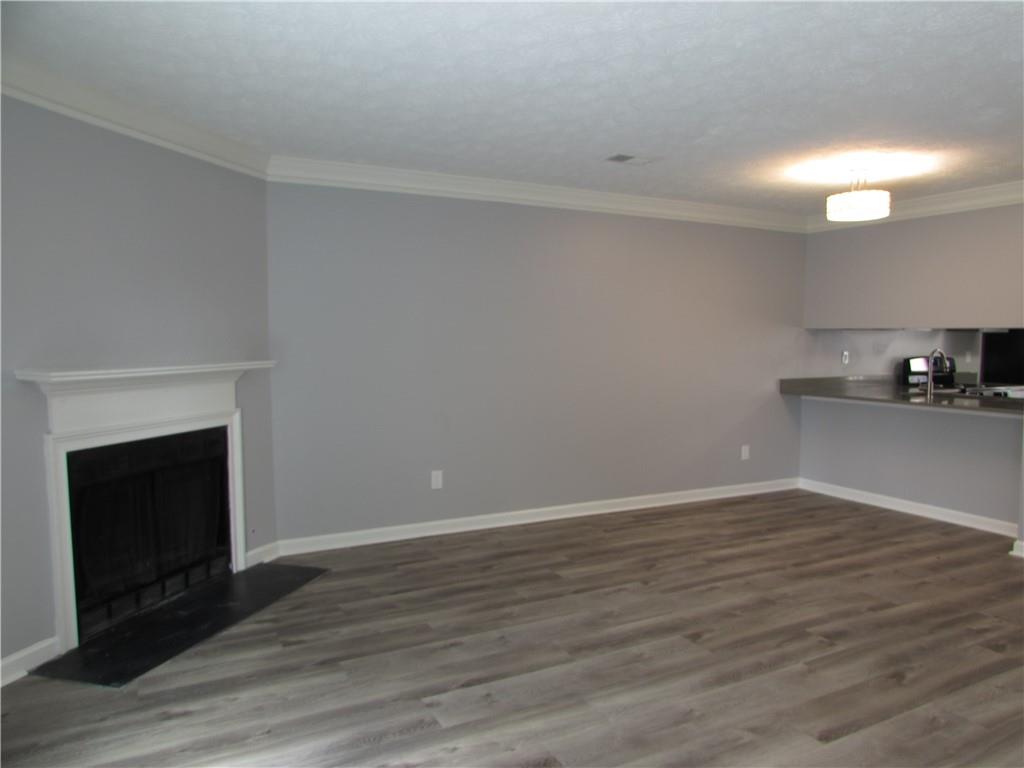 835 Heritage Valley Road Norcross, GA 30093 - Photo 20 of 34 a view of an empty room with wooden floor and a fireplace