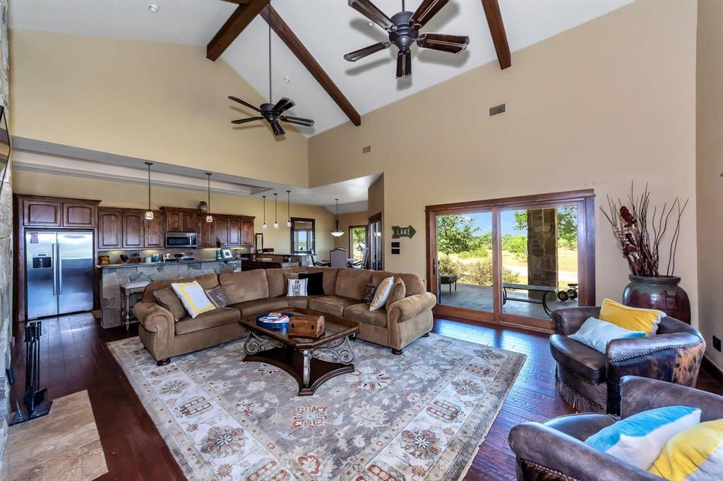 1231 Rawhide Ridge Graford, TX 76449 - Photo 13 of 26 Living room with beam ceiling, ceiling fan, high vaulted ceiling, and wood-type flooring