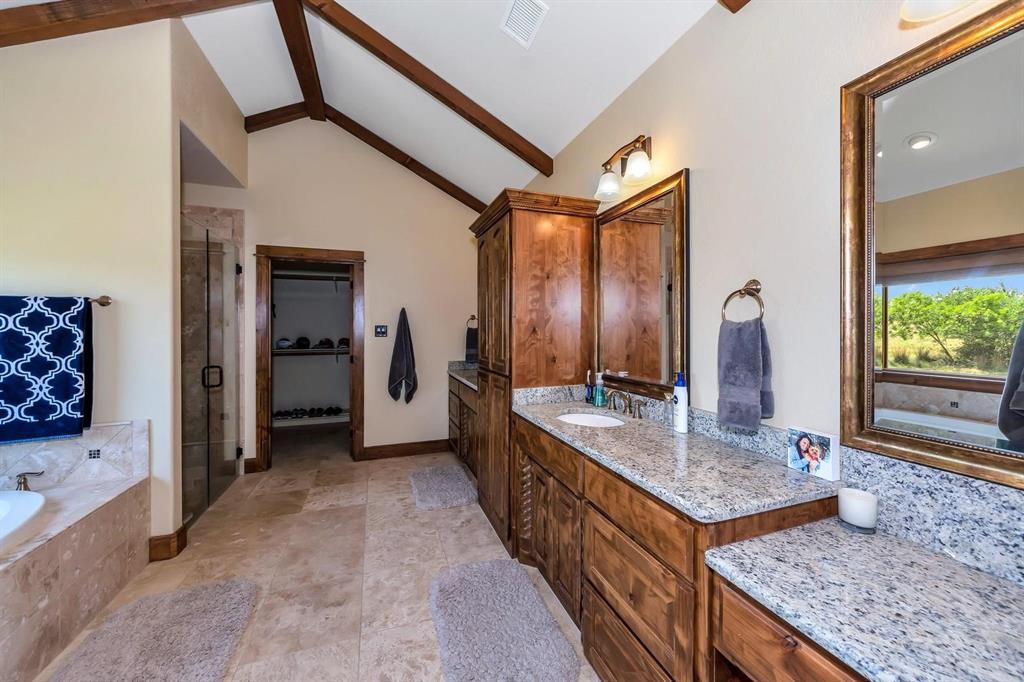1231 Rawhide Ridge Graford, TX 76449 - Photo 20 of 26 Bathroom featuring separate shower and tub, vanity, and lofted ceiling with beams