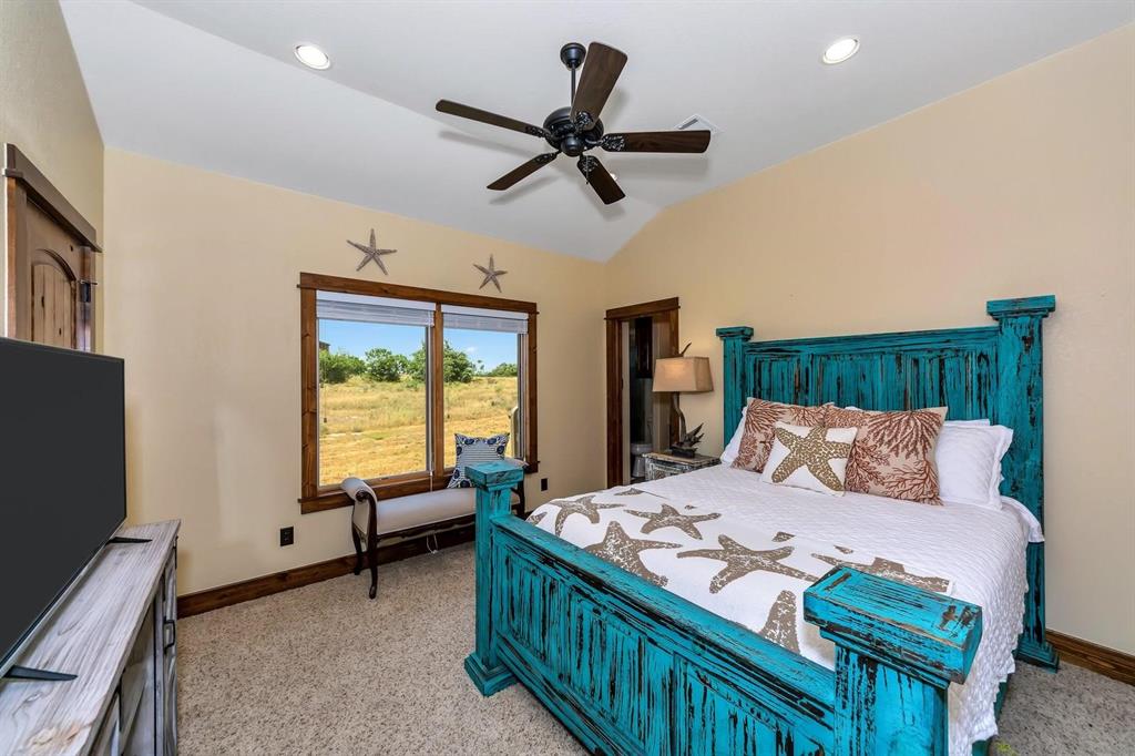 1231 Rawhide Ridge Graford, TX 76449 - Photo 23 of 26 Carpeted bedroom featuring vaulted ceiling and ceiling fan