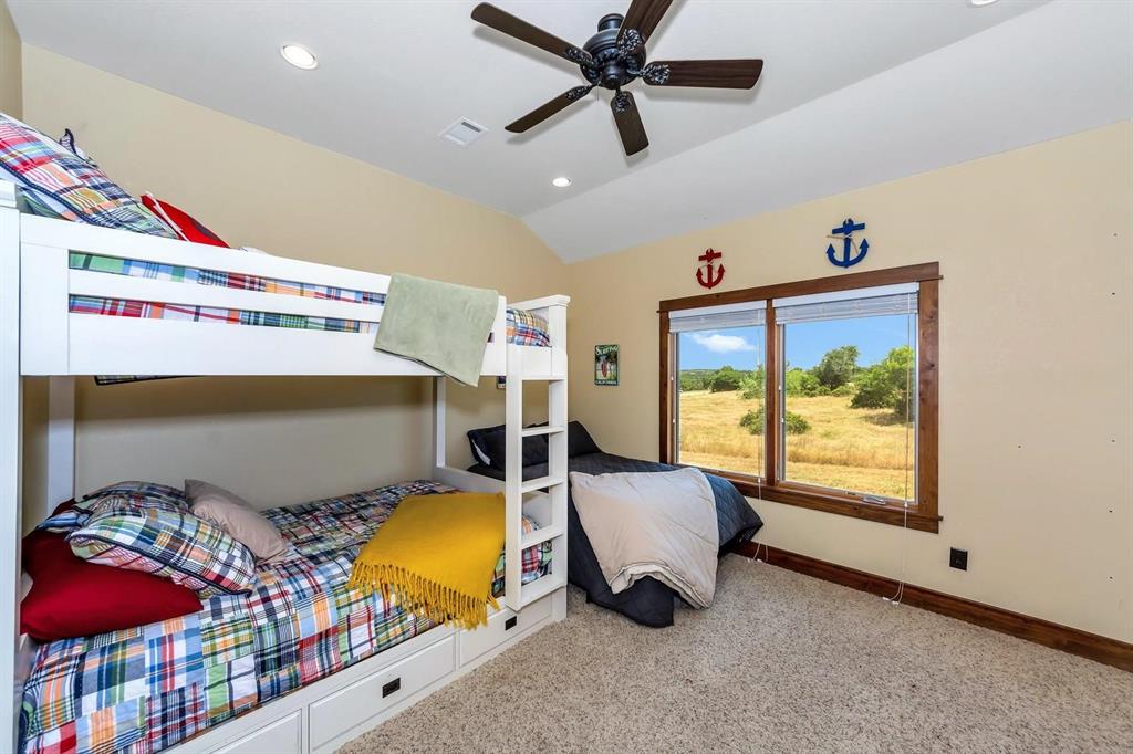1231 Rawhide Ridge Graford, TX 76449 - Photo 24 of 26 Bedroom featuring ceiling fan, light carpet, and vaulted ceiling
