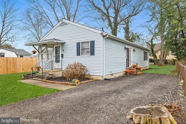 a view of a small house with backyard and wooden fence