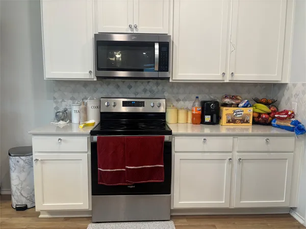 a kitchen with stainless steel appliances granite countertop a stove a microwave and cabinets