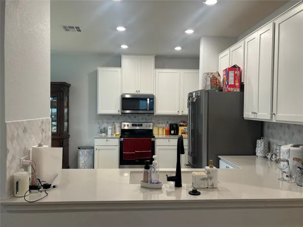 a kitchen with stainless steel appliances kitchen island granite countertop a dining table and chairs
