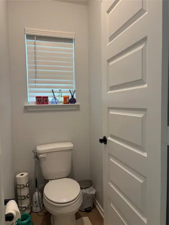 a bathroom with a toilet a sink and a window