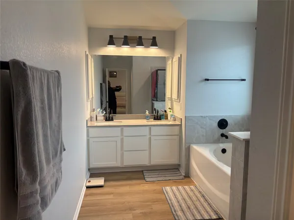 a bathroom with a sink a mirror and a bathtub