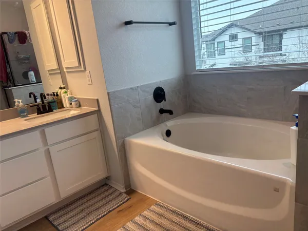 a bathroom with a tub sink and mirror