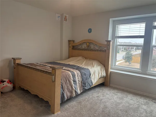 a bed sitting in a bedroom next to a window