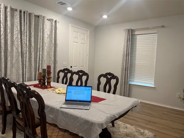 a view of a a dining room with furniture window and wooden floor