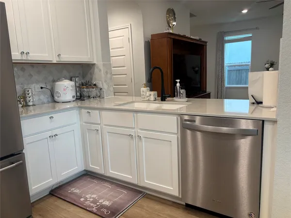 a kitchen with white cabinets and sink