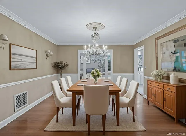 a view of a dining room with furniture a chandelier and wooden floor