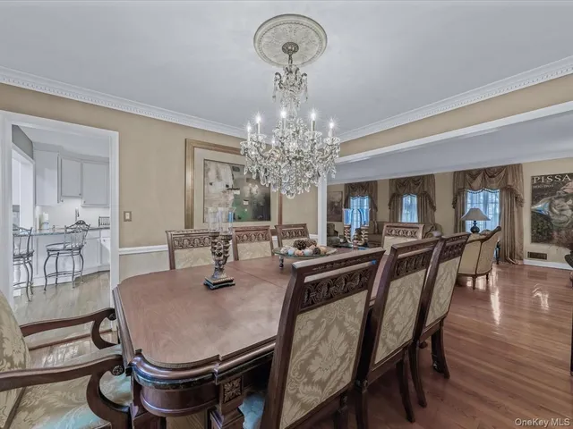 a dining room with furniture a chandelier and wooden floor