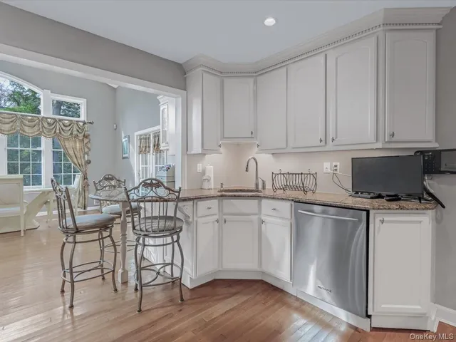 a kitchen with granite countertop white cabinets and white appliances
