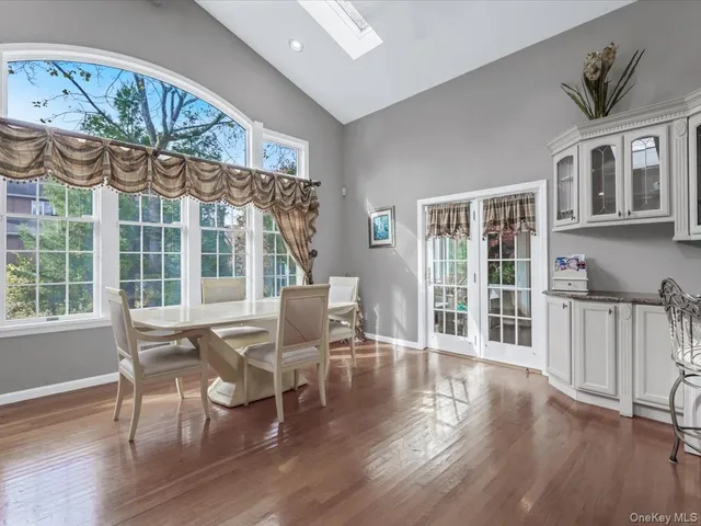 a dining room with wooden floor a glass table and chairs