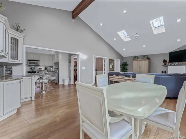 a dining room with stainless steel appliances kitchen island granite countertop a dining table chairs and granite counter tops
