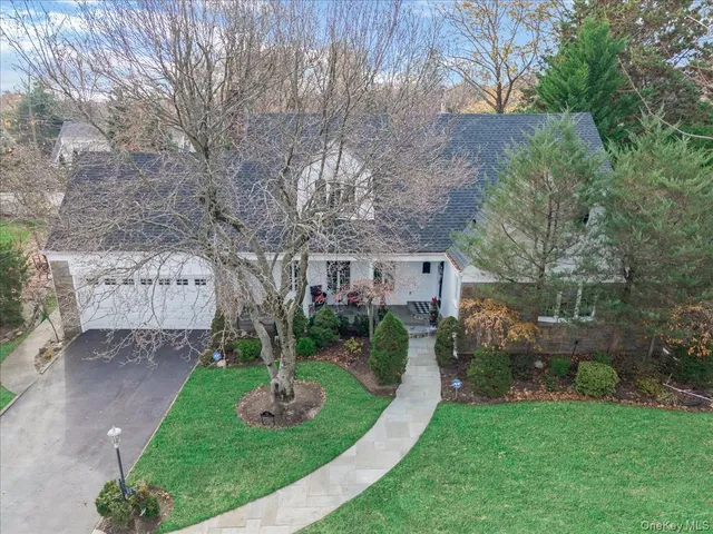 a front view of a house with a garden and trees